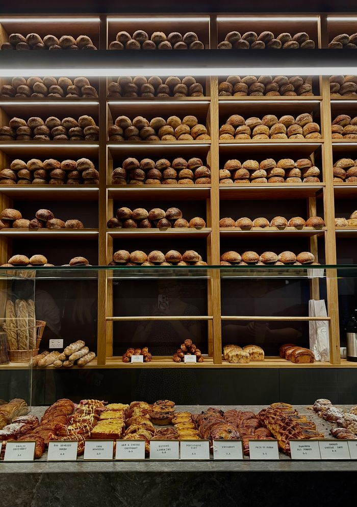 A diverse selection of fresh artisanal breads displayed on shelves in a Melbourne bakery.